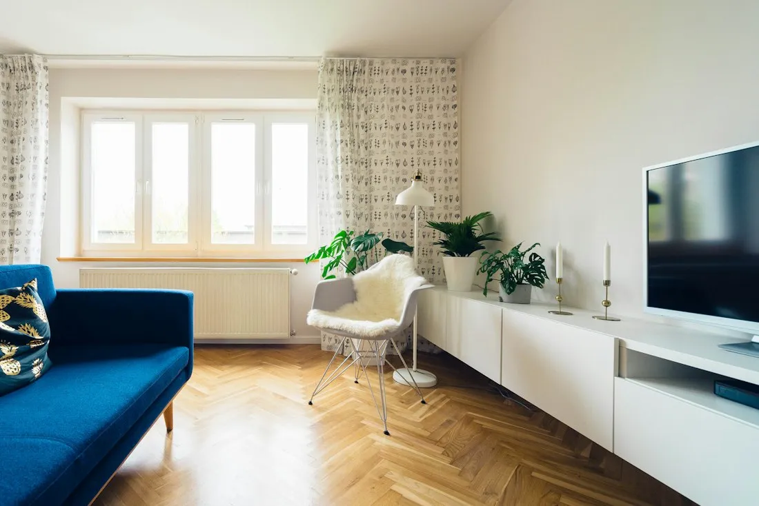 A bright, calm room with plants and a soft chair