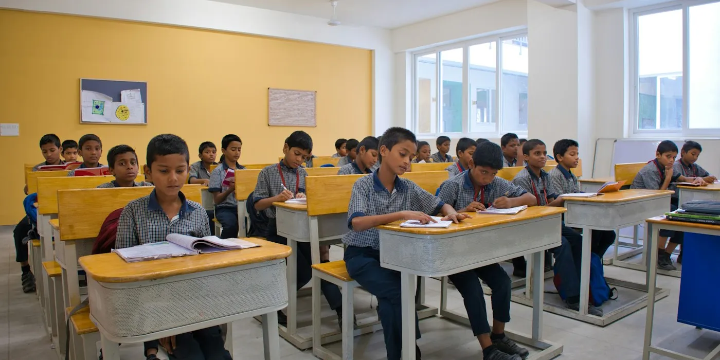 Students in school uniform working at their desks in a classroom