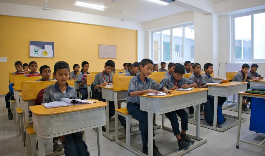 Students in school uniform working at their desks in a classroom